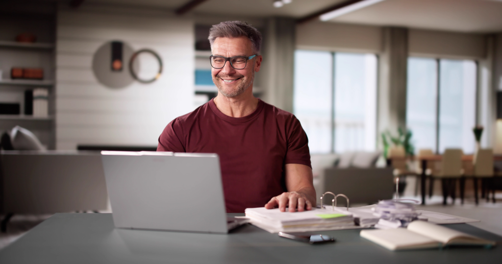 Canadian checking CRA My Account on laptop while reviewing tax documents and budget spreadsheet during tax season